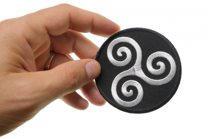 Karma Symbol Iron on Novelty Patch shown on hand for size comparison