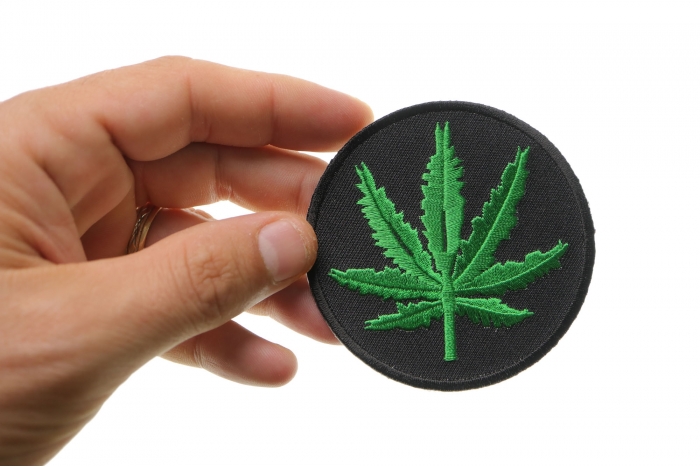 Marijuana Leaf Novelty Iron on Patch shown on hand for size comparison