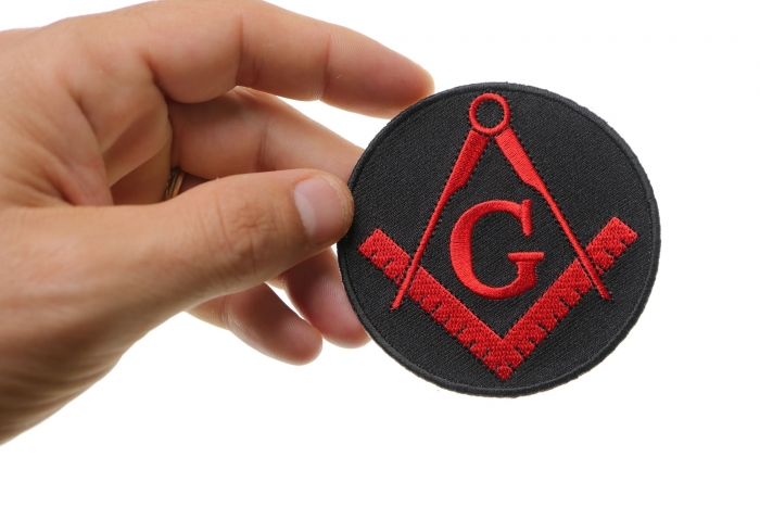 Mason Symbol Novelty Iron on Patch In Red shown on hand for size comparison