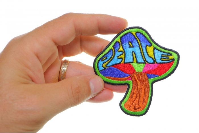 Peace Mushroom Novelty Iron on Patch Psychedelic Hippie shown on hand for size comparison