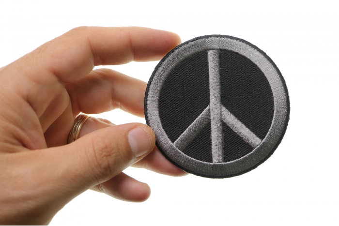 Peace Sign Novelty Iron on Patch Gray On Black shown on hand for size comparison