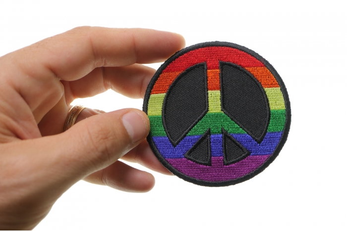 Rainbow Peace Novelty Iron on Patch shown on hand for size comparison
