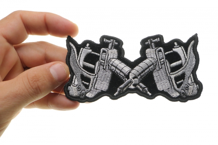 Small Tattoo Guns Novelty Iron on Patch shown on hand for size comparison