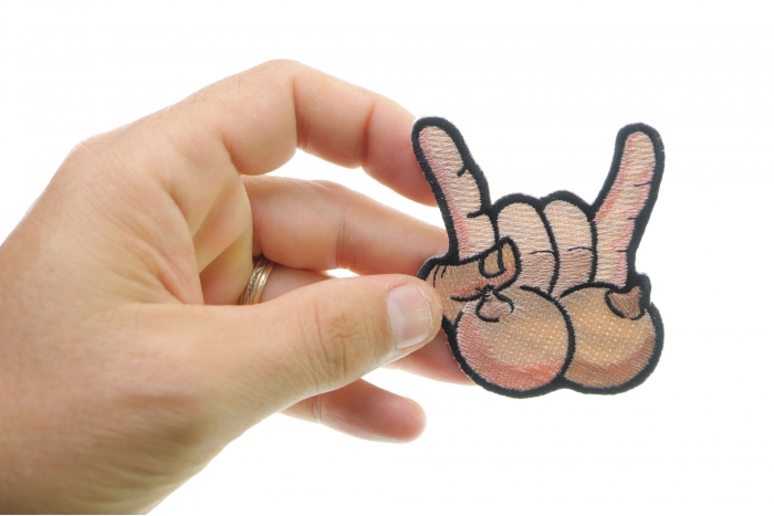 Tits and Rock On Fun Iron On Novelty Patch shown on hand for size comparison