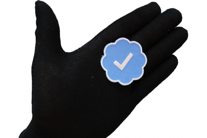 Twitter verified Patch shown on hand for size comparison