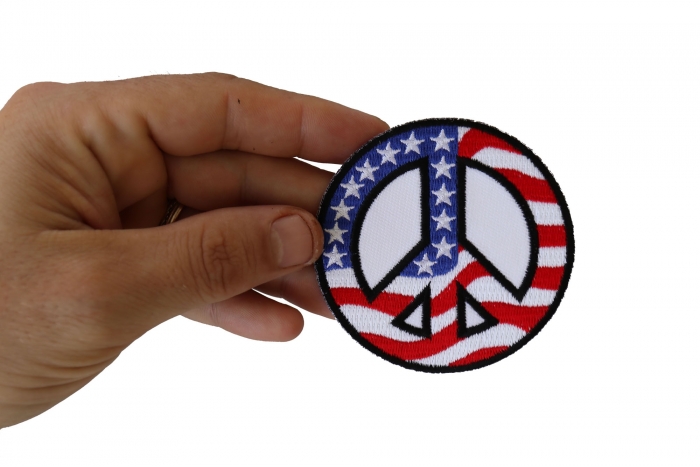 US Flag Peace Sign Novelty Iron on Patch shown on hand for size comparison