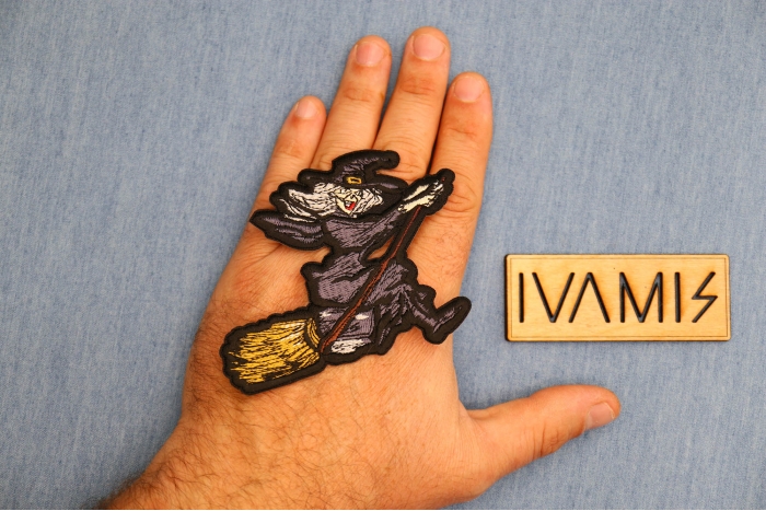 Witch Riding Broom Patch shown on hand for size comparison