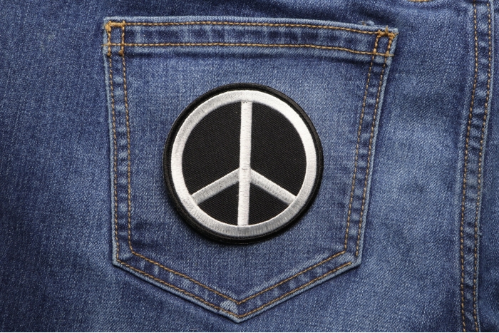 Black White Peace Sign Novelty Iron on Patch shown on jeans