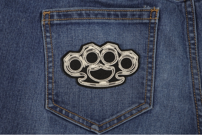 Brass Knuckles Iron on Novelty Patch shown on jeans