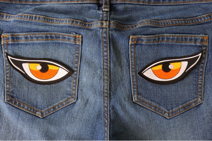 Medium Orange Eyes Iron on Patch shown on jeans