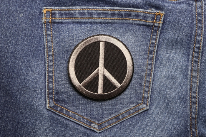 Peace Sign Novelty Iron on Patch Gray On Black shown on jeans