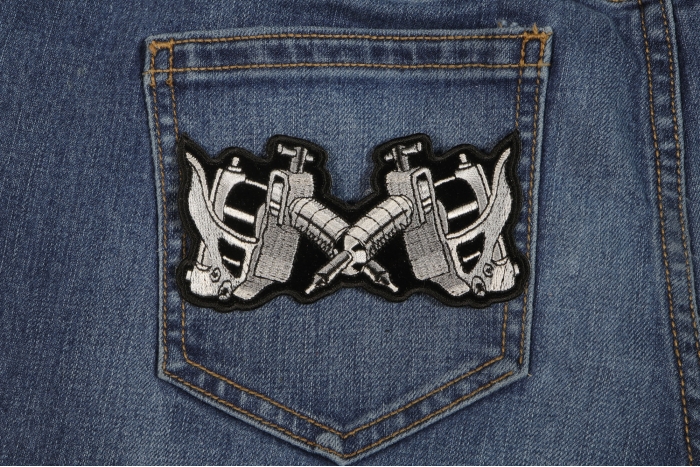 Small Tattoo Guns Novelty Iron on Patch shown on jeans