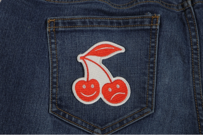 Smiling and Frowning Cherries Iron on Patch shown on jeans