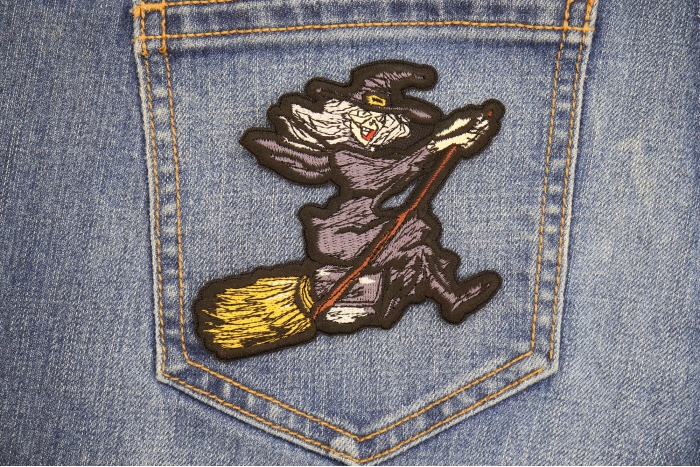 Witch Riding Broom Patch shown on jeans