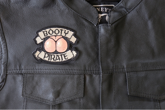 Booty Pirate Patch - 4x3.25 inch - Embroidered Iron on Patch shown on leather vest
