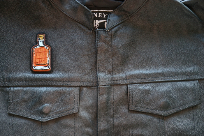 Whiskey Bottle Iron on Patch shown on leather vest