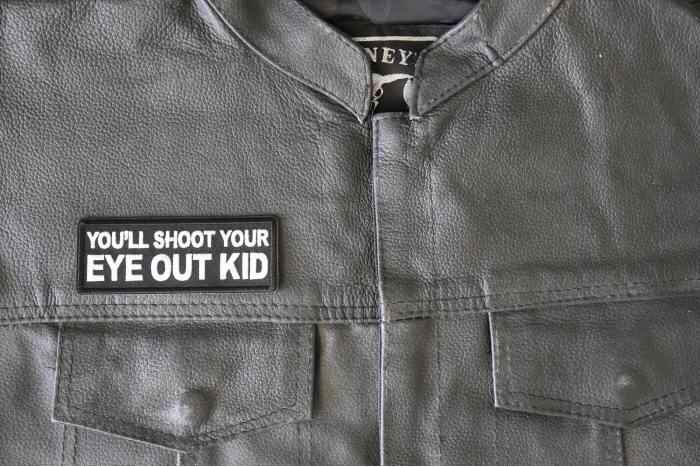 You'll Shoot Your Eye Out Kid Patch - 4x1.5 inch - Embroidered Iron on Patch shown on leather vest