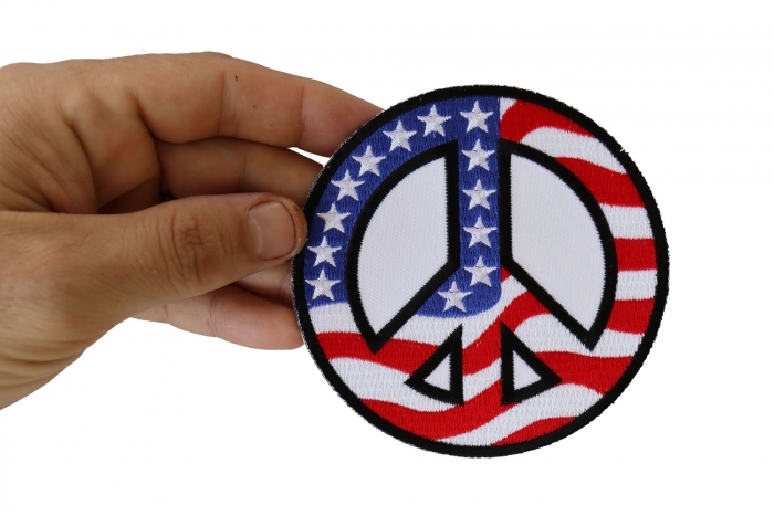 American Flag Peace Sign Patriotic Iron on Patch shown on hand for size comparison