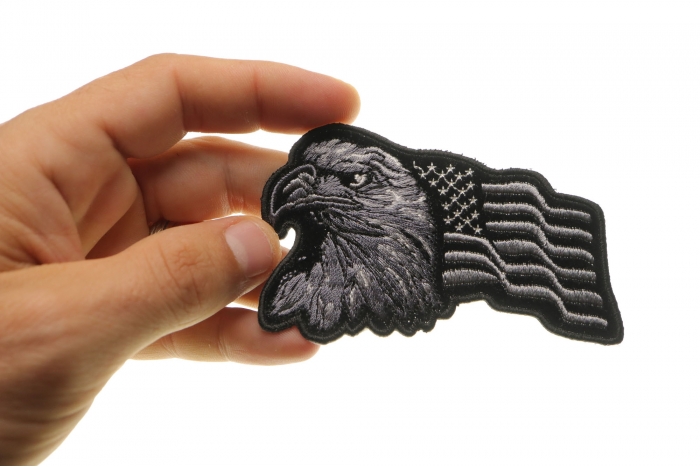 Eagle With Waving Flag Black Silver Patriotic Iron on Patch shown on hand for size comparison