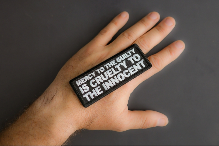 Mercy To The Guilty Is Cruelty To The Innocent Patch shown on hand for size comparison