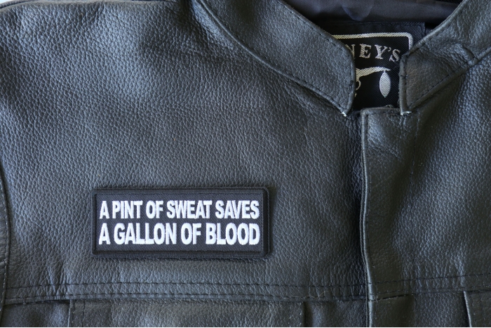 A Pint of Sweat Saves a Gallon of Blood Patch - 4x1.5 inch - Embroidered Iron on Patch shown on leather vest