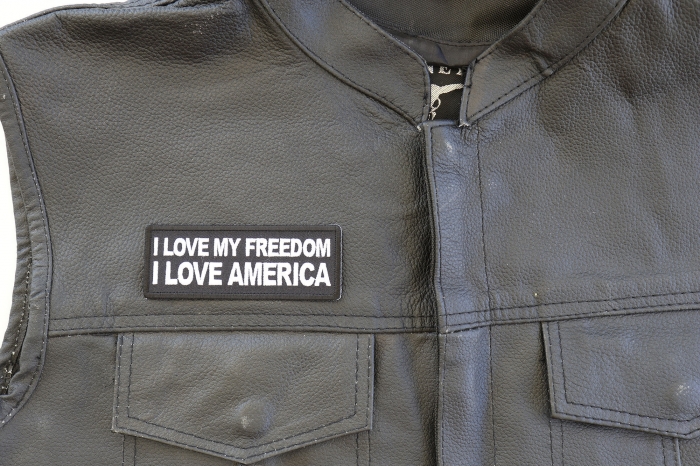 I Love My Freedom I Love America Patch - 4x1.5 inch. Embroidered Iron on Patch shown on leather vest