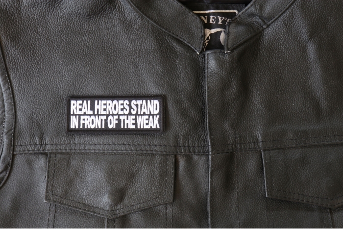 Real Heroes Stand In front of the Weak Patch - 4x1.5 inch - Embroidered Iron on Patch shown on leather vest