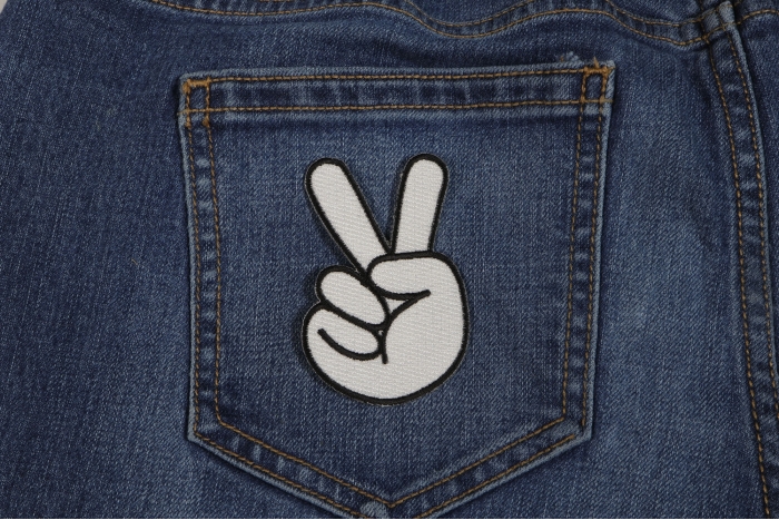 Peace Hand Sign in White Iron on Patch shown on jeans
