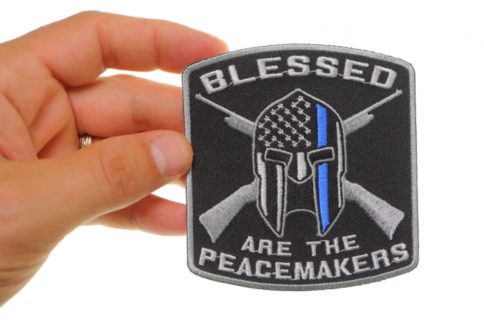 Blessed Are The Peacemakers Thin Blue Line Patch For Law Enforcement shown on hand for size comparison