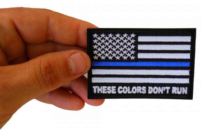 These Colors Don't Run Blue Line US Flag Patch shown on hand for size comparison