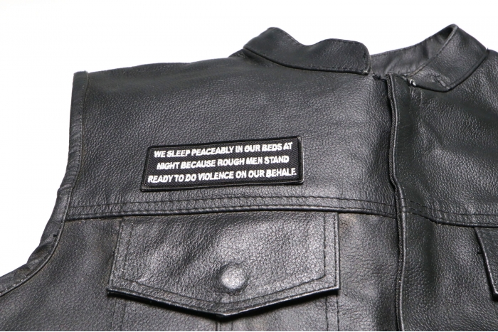 We Sleep Peaceably in Our Beds at Night Because Rough Men Stand Ready to do Violence on Our Behalf Patch - 4x1.5 inch. Embroidered Iron on Patch shown on leather vest