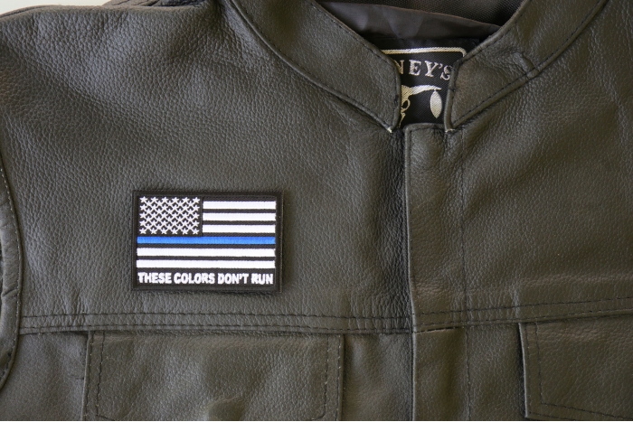 These Colors Don't Run Blue Line US Flag Patch - 3x2 inch. Embroidered Iron on Patch shown on leather vest