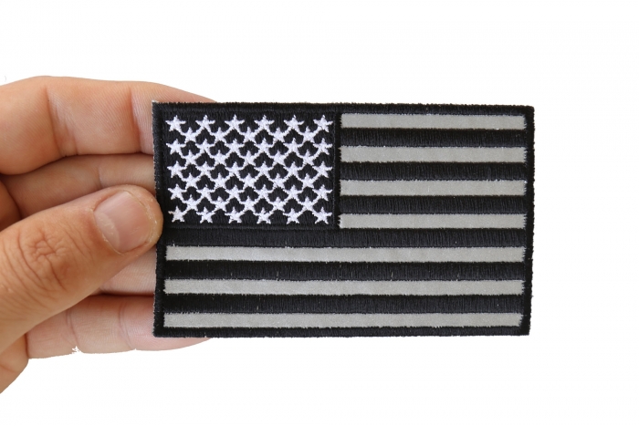 American Flag Black and Reflective 4 Inch Patch shown on hand for size comparison
