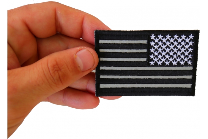 Reverse Black Reflective US Flag Patch shown on hand for size comparison