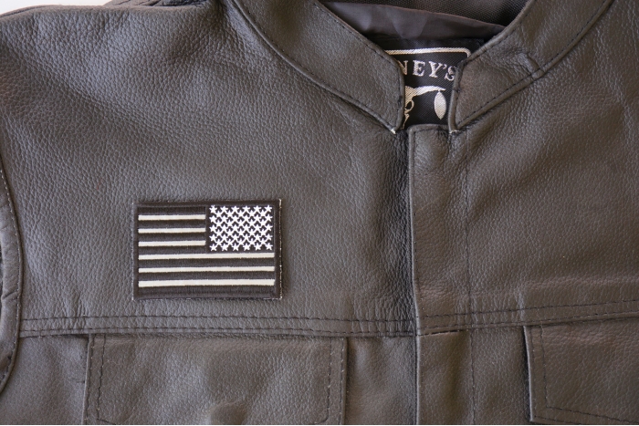 Reverse Black Reflective US Flag Patch - 3x2 inch. Embroidered Iron on Patch shown on leather vest