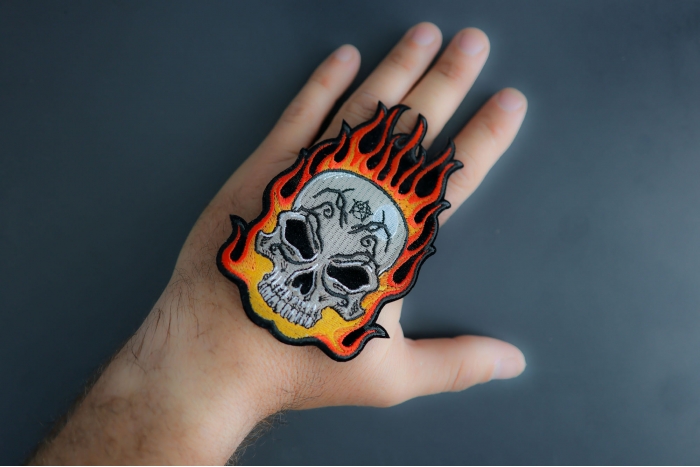 Flaming Tattoo Skull Patch shown on hand for size comparison
