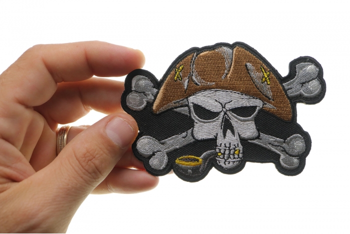 Pipe Smoking Skull with Hat Iron on Patch shown on hand for size comparison
