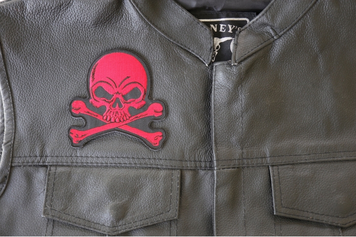Red Skull and Cross Bones Patch - 4x4 inch. Embroidered Iron on Patch shown on leather vest