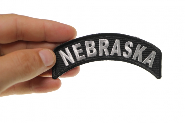 Nebraska Patch Iron on State Rocker shown on hand for size comparison