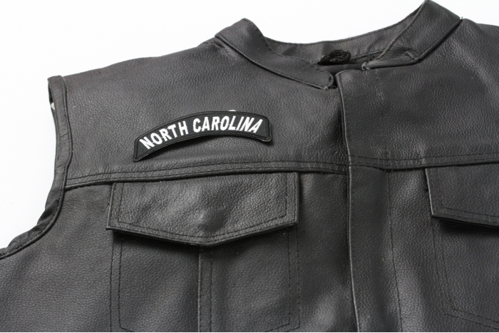 North Carolina Patch - 4x1.75 inch. Embroidered Iron on Patch shown on leather vest