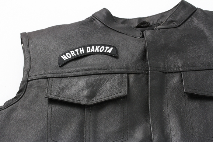 North Dakota Patch - 4x1.75 inch. Embroidered Iron on Patch shown on leather vest