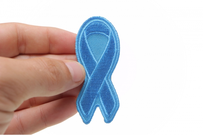 Blue Ribbon Patch For Awareness In Child Abuse and Bullying shown on hand for size comparison
