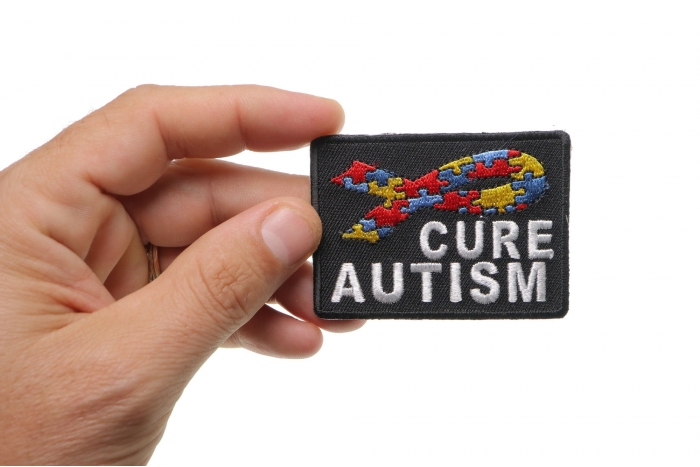 Cure Autism Puzzle Pieces Ribbon Patch shown on hand for size comparison