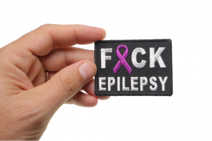 FCK Epilepsy Patch shown on hand for size comparison