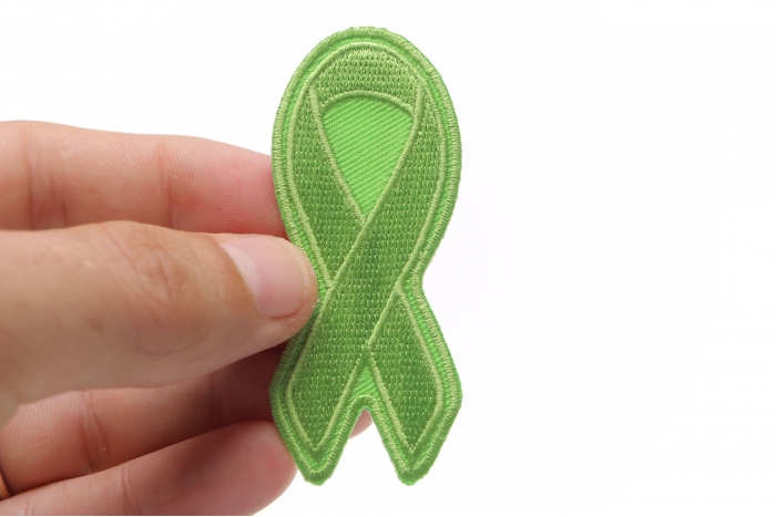Green Ribbon Patch For Environmental Awareness shown on hand for size comparison