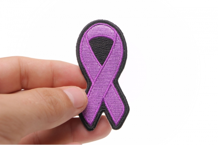 Purple Ribbon Patch For Breast Cancer Survivors shown on hand for size comparison