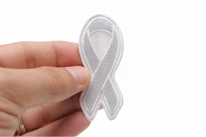 White Lung Cancer Awareness Ribbon Patch shown on hand for size comparison