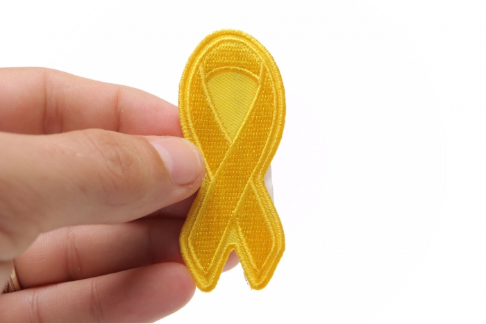Yellow Ribbon Patch shown on hand for size comparison