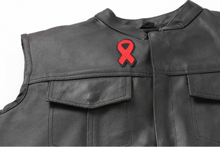 Red Ribbon Aids Awareness Patch - 3x1.25 inch. Embroidered Iron on Patch shown on leather vest