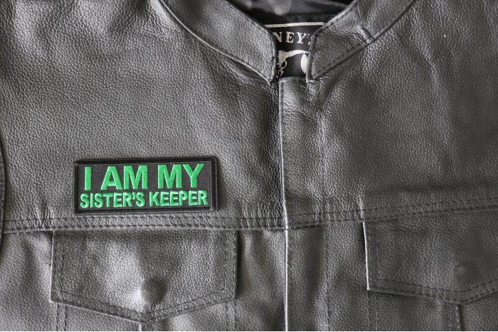 I am My Sister's Keep Patch Green - 4x1.5 inch - Embroidered Iron on Patch shown on leather vest